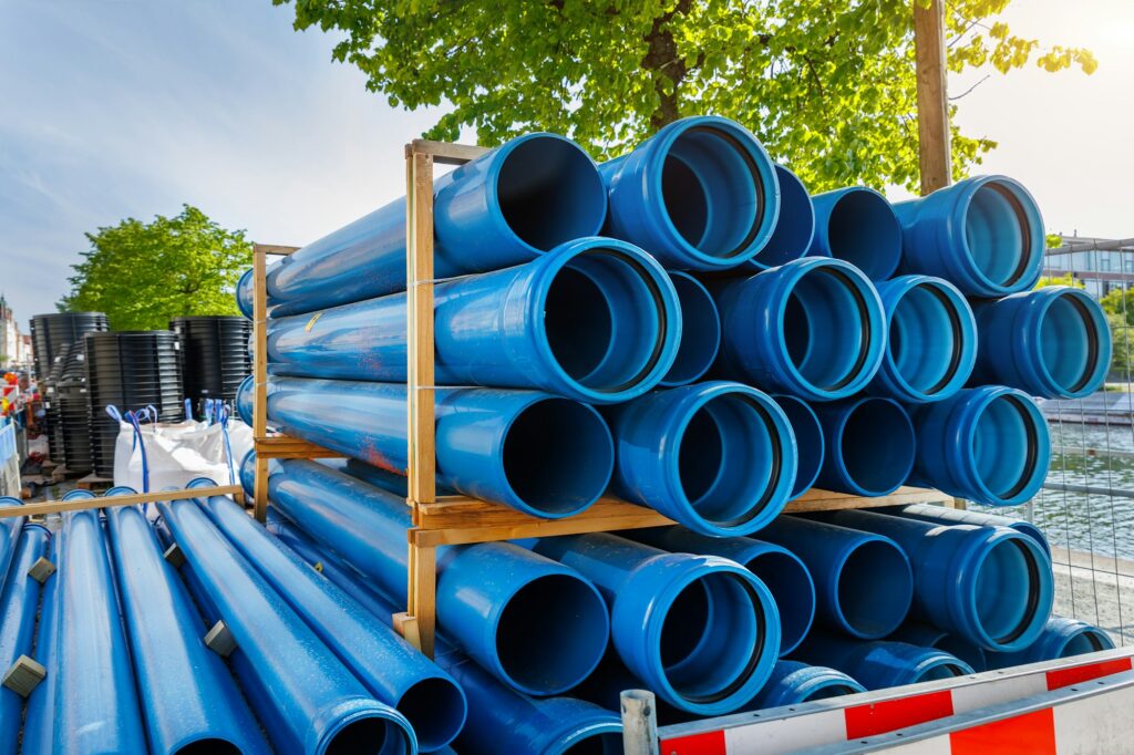 Close-up blue PVC plumbing pipes stacked wooden pallets replacement at german city street
